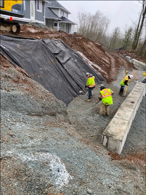 Retaining wall construction with workers in safety gear